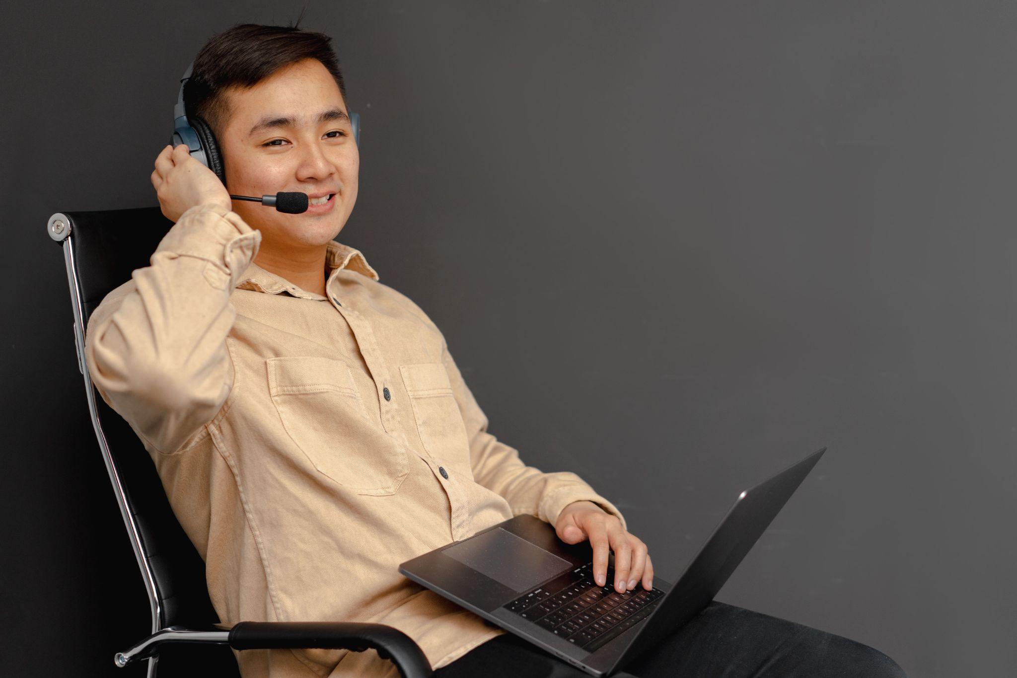 Virtual assistant working on a laptop with a headset on