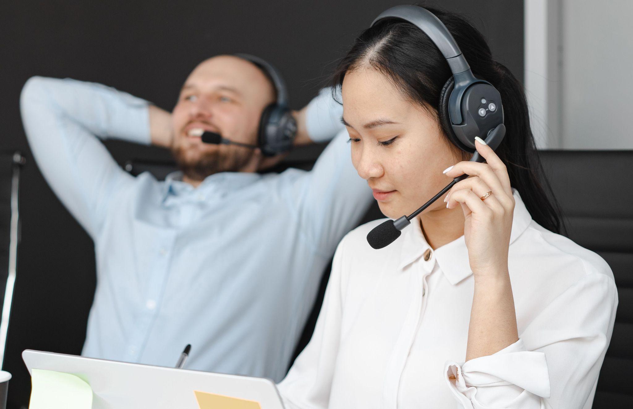 Customer support team members wearing headsets in an office