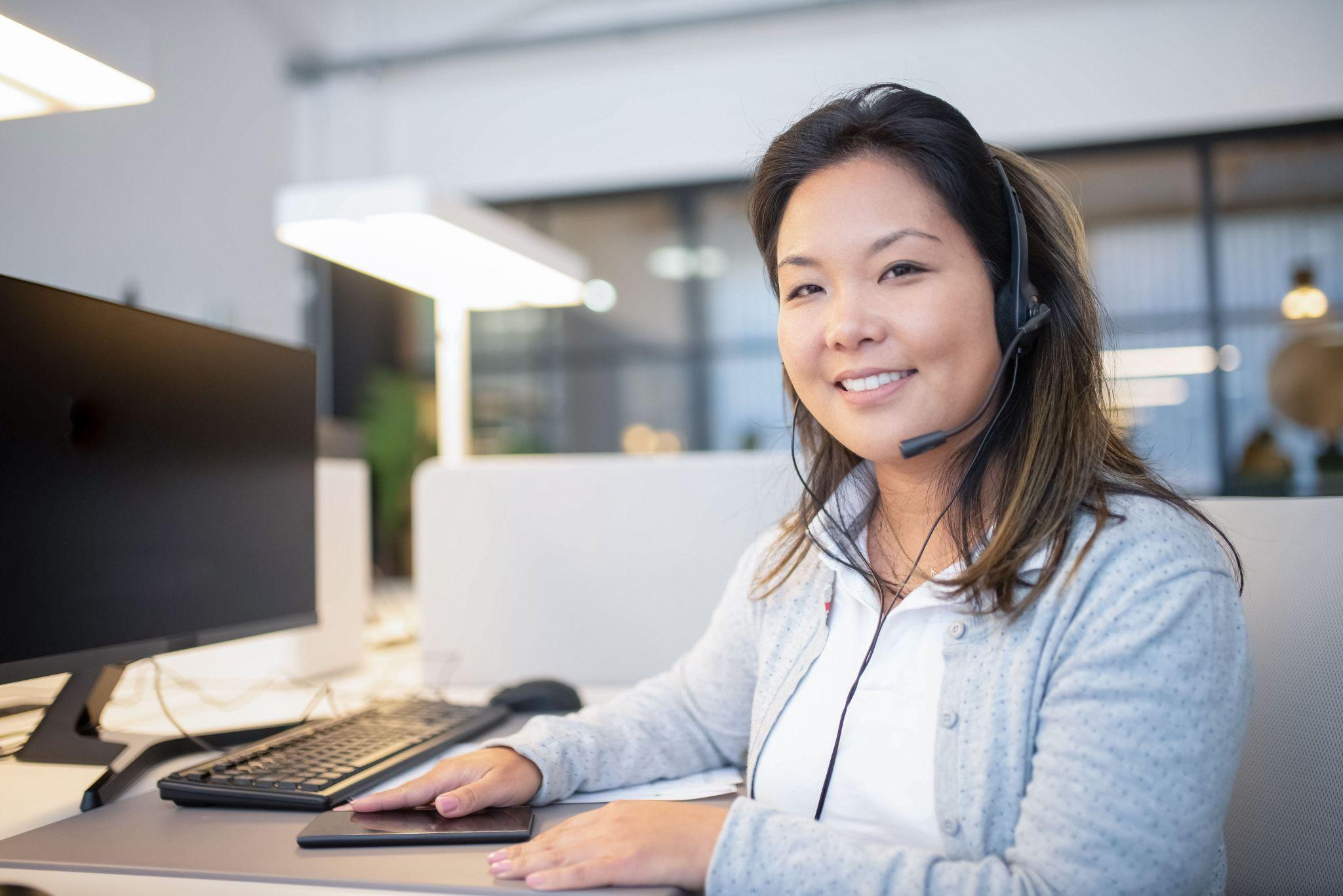 Virtual assistant with a headset working at a desk in an office